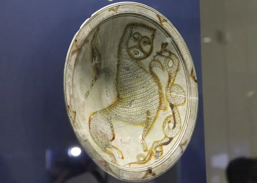 A dish with the image of a lion and a snake